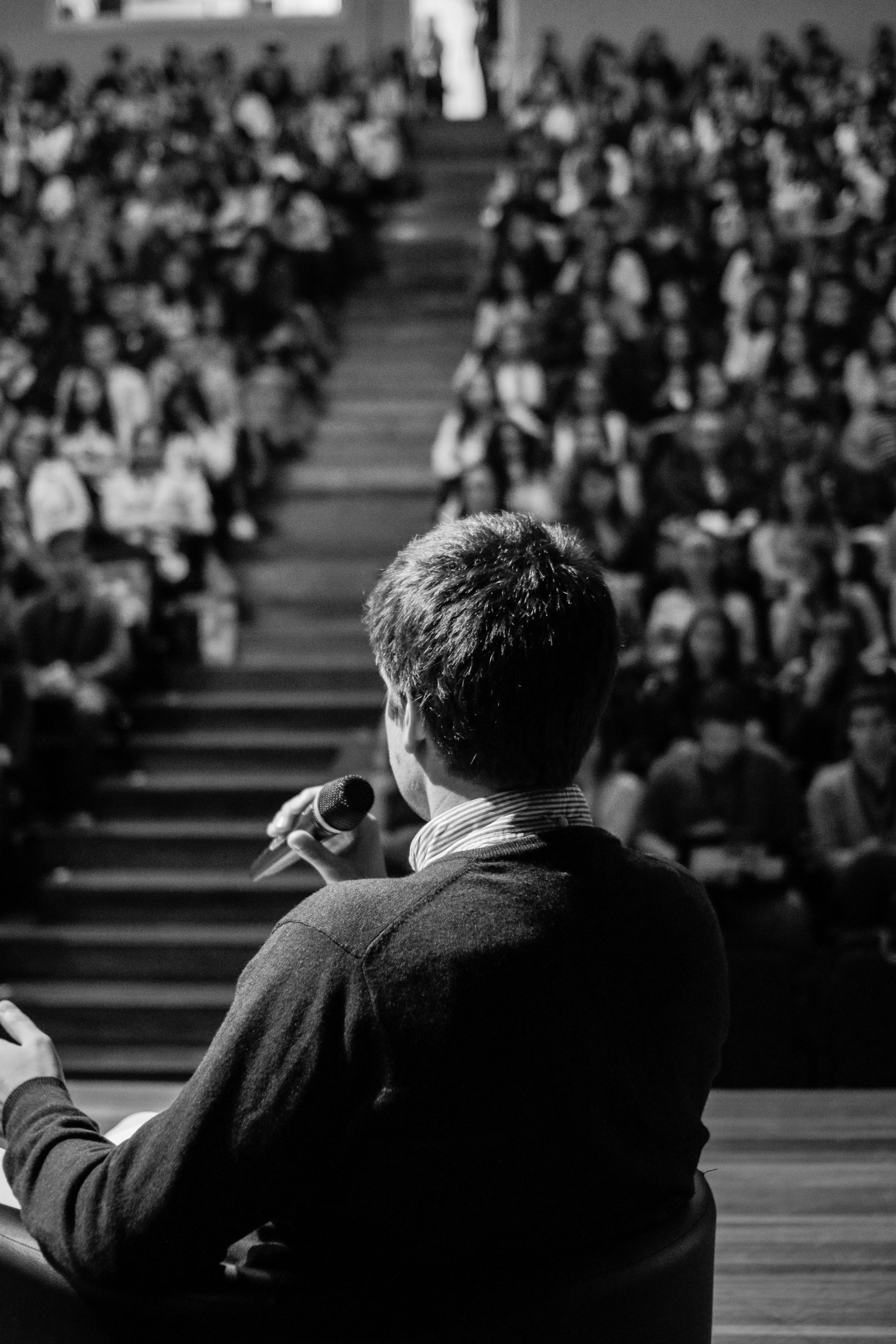 Un relatore dialoga con il pubblico in un auditorium